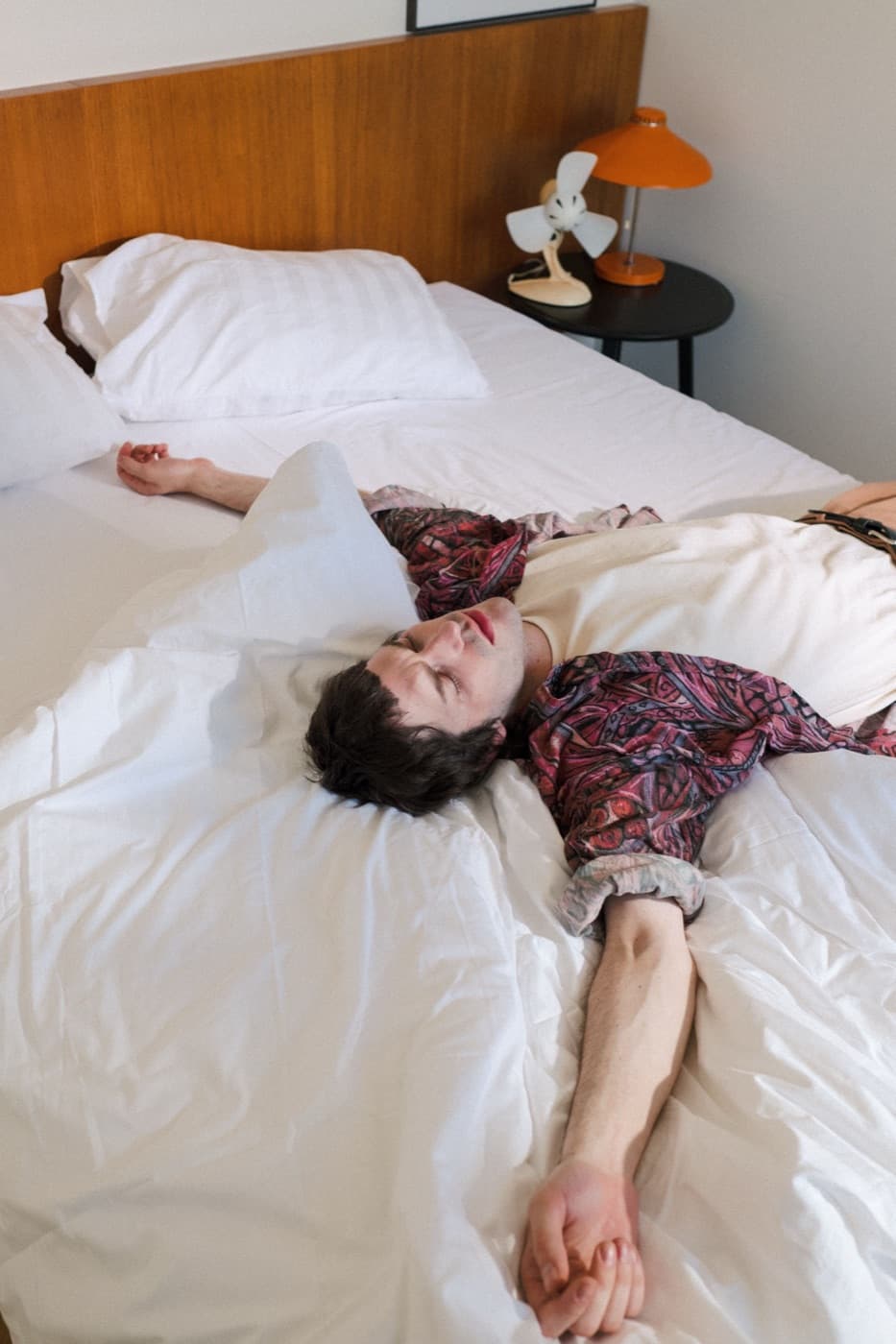 A person resting and stretching out on a bed